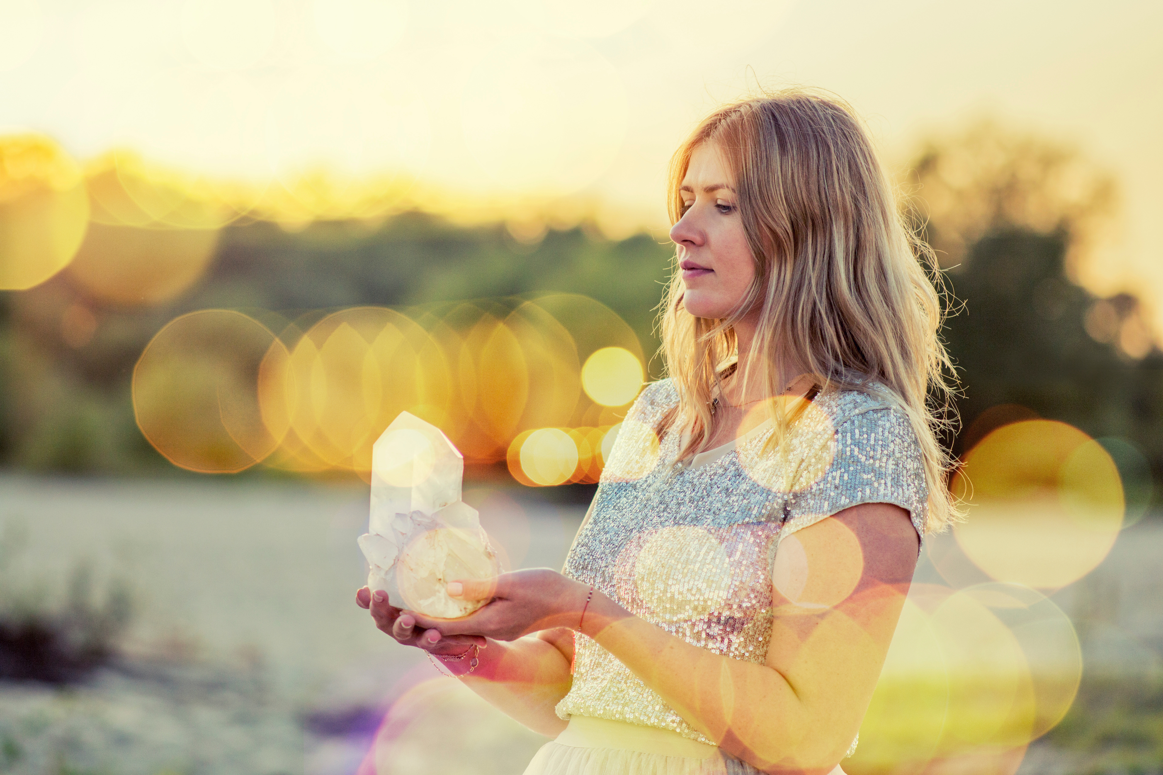 Beautiful woman on beach holding healing crystals